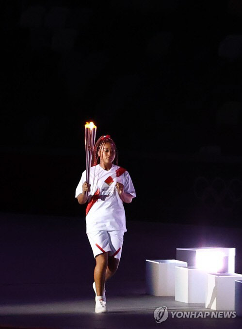 23일 일본 도쿄 신주쿠 국립경기장에서 열린 2020 도쿄올림픽 개막식에서 오사카 나오미가 성화를 들고 뛰고 있다. 연합뉴스